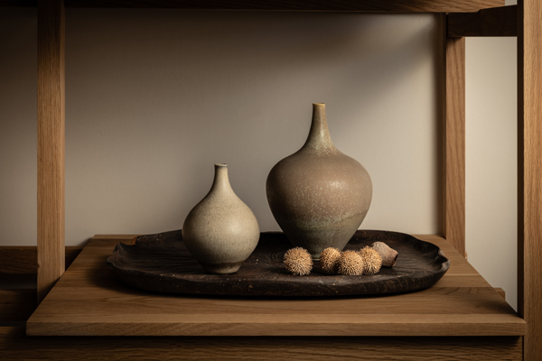 木の棚の上、トレーにのせた2つの花器と木の実