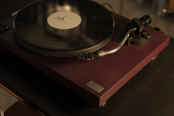 バーガンディ色のTechnicsターンテーブルとレコード盤、トーンアーム